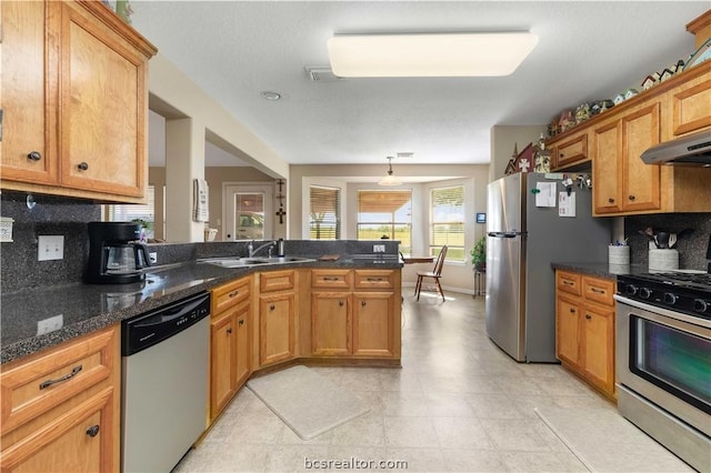 kitchen featuring kitchen peninsula, backsplash, stainless steel appliances, and sink