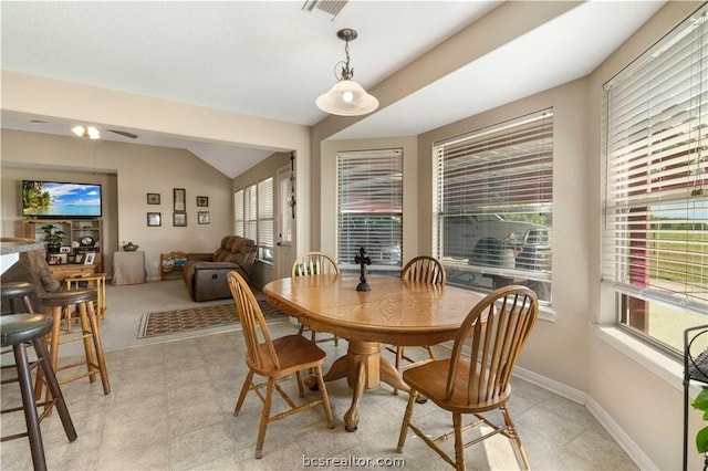 tiled dining room featuring lofted ceiling