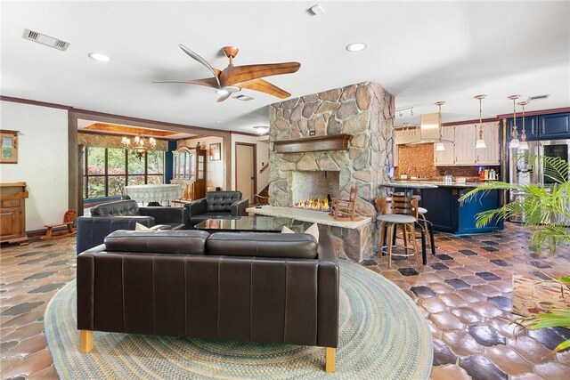 1309 Rock Dam Rd, Marlin, TX 76661 - living area with ceiling fan with notable chandelier, ornamental molding, a stone fireplace, visible vents, and recessed lighting