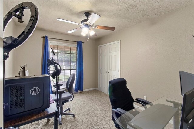 home office with carpet flooring, ceiling fan, and a textured ceiling