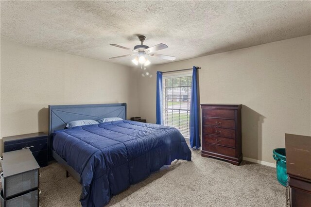 bedroom with ceiling fan, light carpet, and a textured ceiling