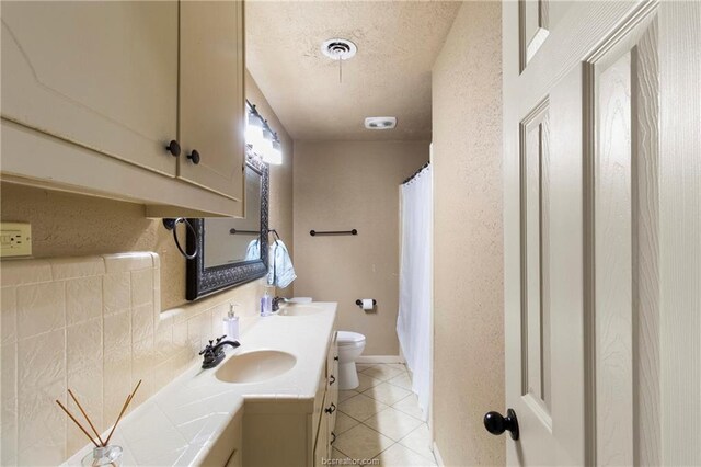 bathroom with tasteful backsplash, tile patterned floors, toilet, vanity, and a shower with shower curtain