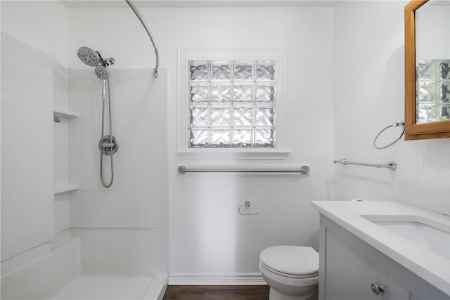 bathroom with toilet, vanity, and walk in shower