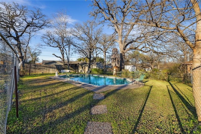 view of swimming pool featuring a yard