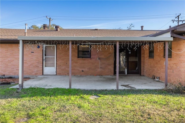 back of property with a lawn and a patio