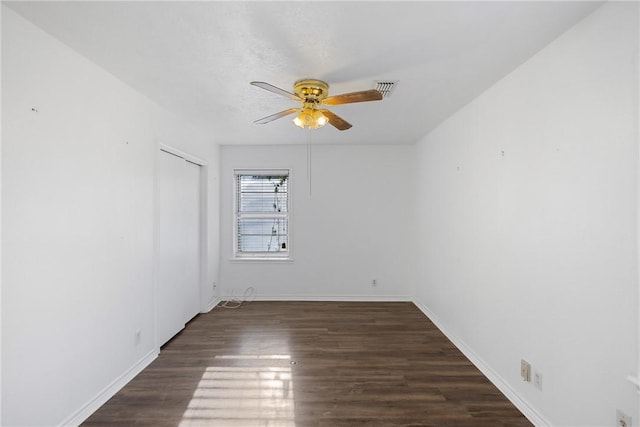 spare room with dark wood-type flooring and ceiling fan