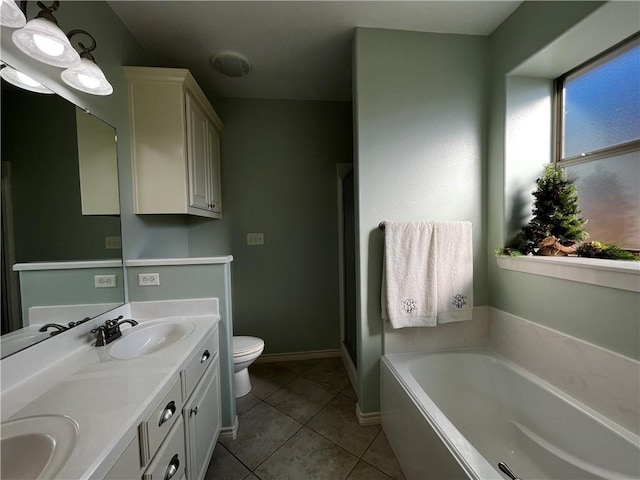 full bathroom featuring a bath, toilet, a sink, and tile patterned floors