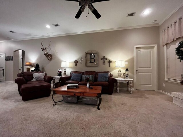 living room with ornamental molding, arched walkways, light colored carpet, and visible vents
