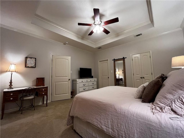 bedroom featuring a raised ceiling, visible vents, crown molding, and a barn door