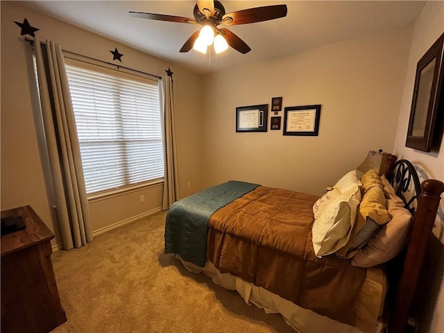 bedroom with a ceiling fan, light colored carpet, and baseboards