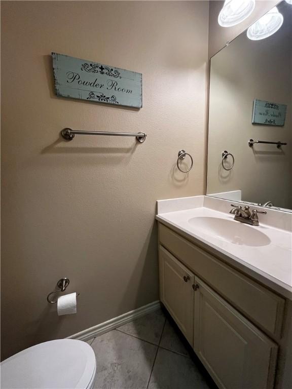 bathroom featuring toilet, tile patterned flooring, vanity, and baseboards