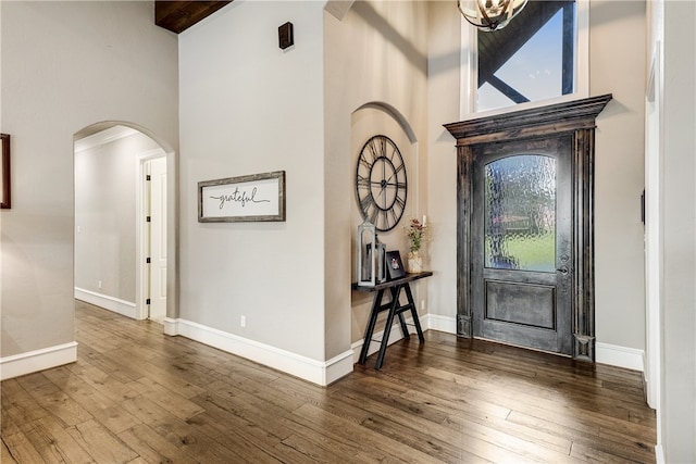 4675 River Garden Ct, Bryan, TX 77808 - entrance foyer with a high ceiling, arched walkways, hardwood / wood-style flooring, and baseboards