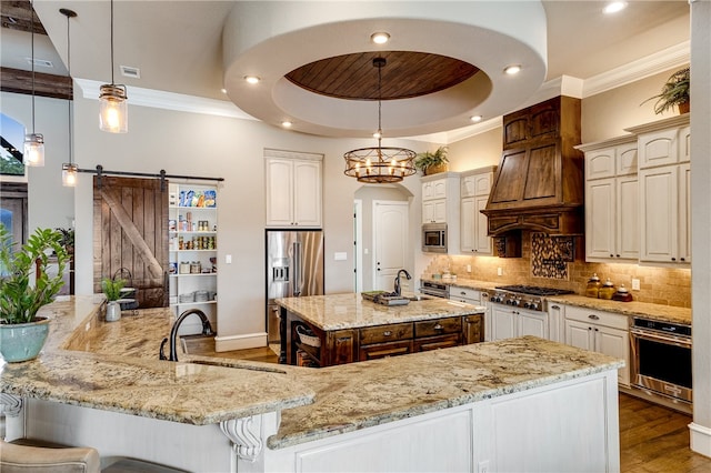 4675 River Garden Ct, Bryan, TX 77808 - kitchen featuring appliances with stainless steel finishes, a spacious island, a sink, a barn door, and backsplash