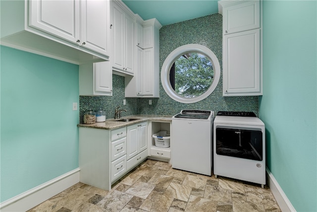 4675 River Garden Ct, Bryan, TX 77808 - laundry room featuring cabinet space, washing machine and clothes dryer, light stone finish flooring, and baseboards