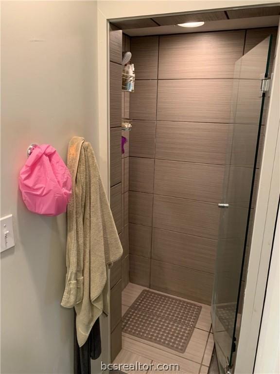 bathroom with tile patterned flooring and a shower with door