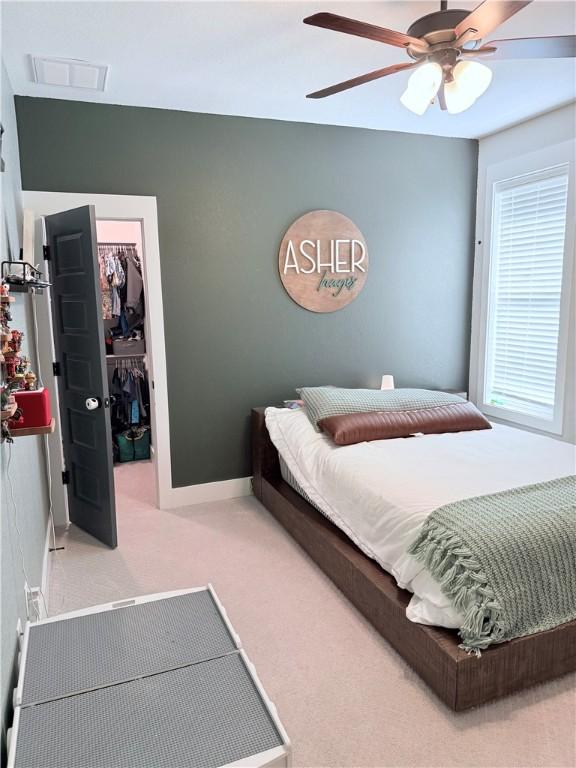 4203 Lismore Ln, College Station, TX 77845 - carpeted bedroom with a walk in closet, a closet, a ceiling fan, and baseboards