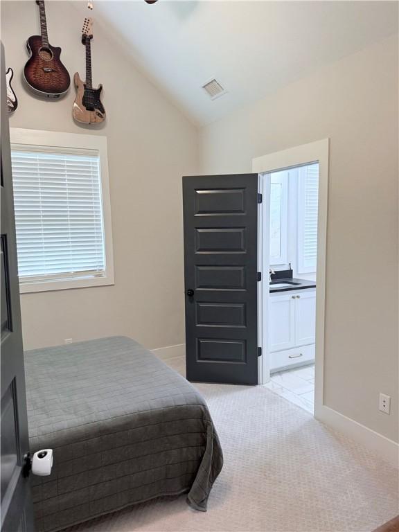 4203 Lismore Ln, College Station, TX 77845 - bedroom with lofted ceiling, light carpet, baseboards, and ensuite bathroom