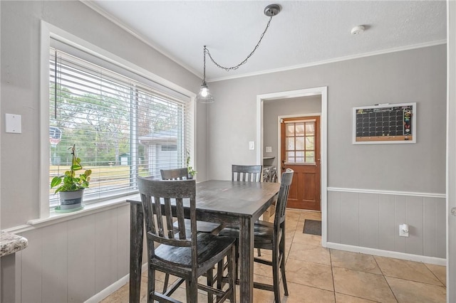 tiled dining room featuring a textured ceiling, wood walls, and crown molding