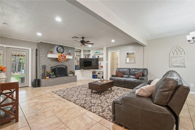 tiled living room with built in shelves, ceiling fan, a fireplace, and a textured ceiling