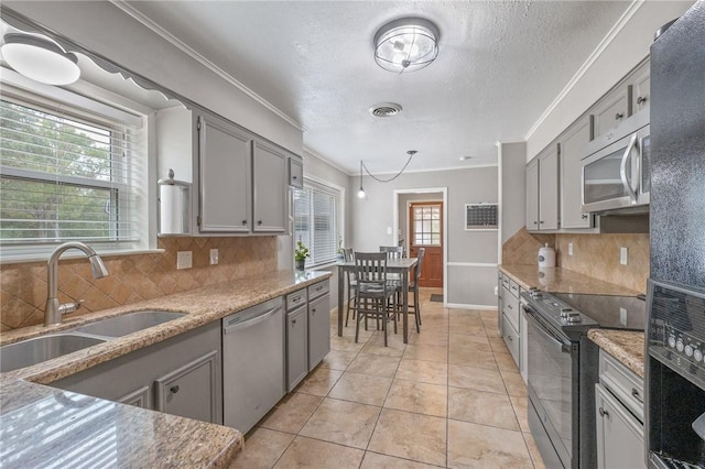 kitchen with tasteful backsplash, sink, a healthy amount of sunlight, and appliances with stainless steel finishes