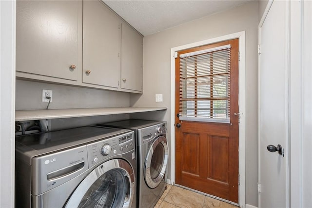 clothes washing area featuring washer and dryer, light tile patterned floors, cabinets, and a textured ceiling