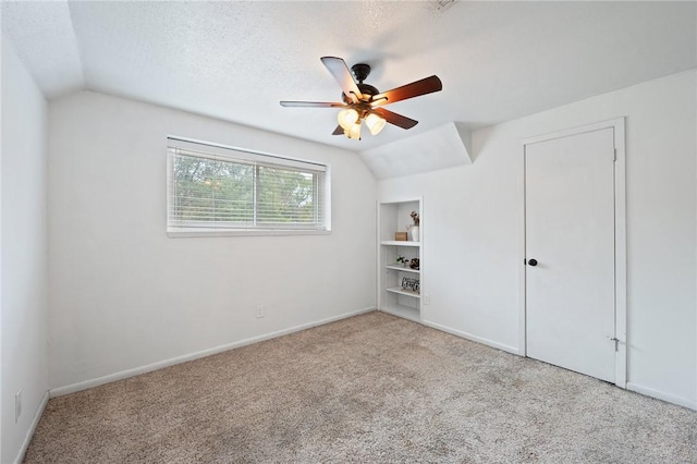 unfurnished bedroom featuring light colored carpet, vaulted ceiling, and ceiling fan