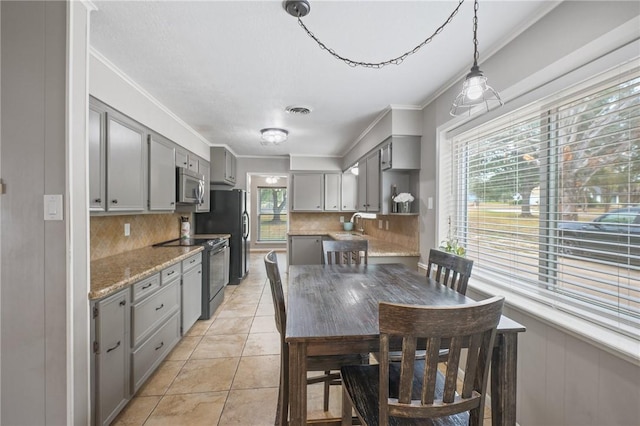 kitchen with plenty of natural light, backsplash, and appliances with stainless steel finishes