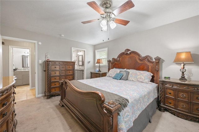 bedroom featuring light carpet, ensuite bath, and ceiling fan