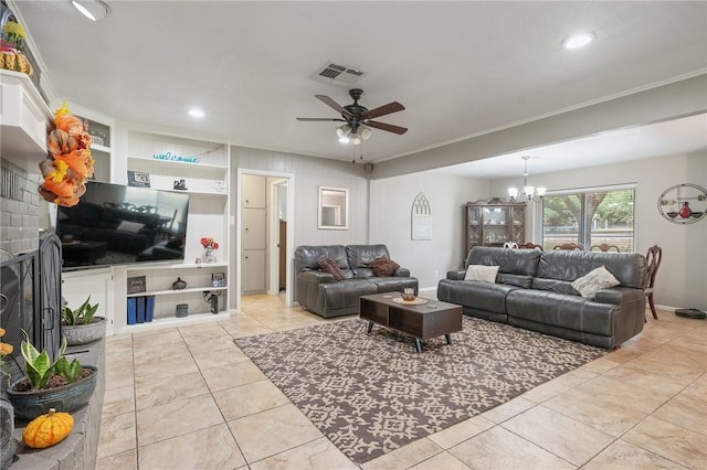 living room with built in features, light tile patterned floors, ceiling fan with notable chandelier, and a brick fireplace