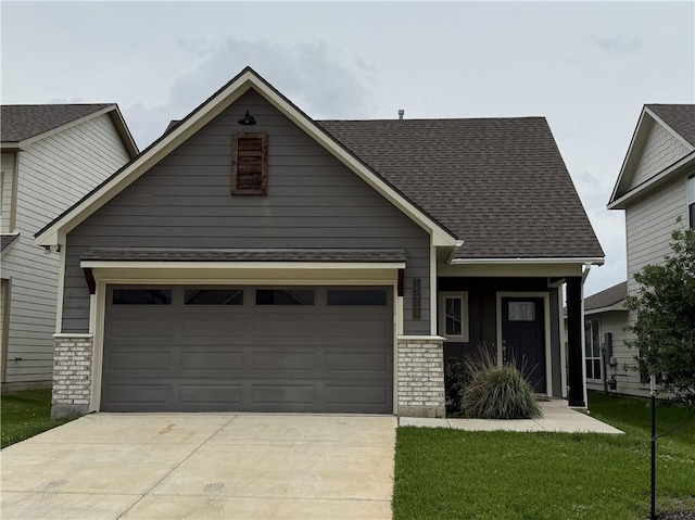 craftsman house featuring an attached garage, a front lawn, roof with shingles, and concrete driveway