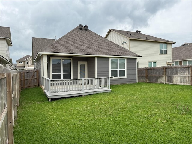 rear view of house with a lawn, a fenced backyard, and roof with shingles