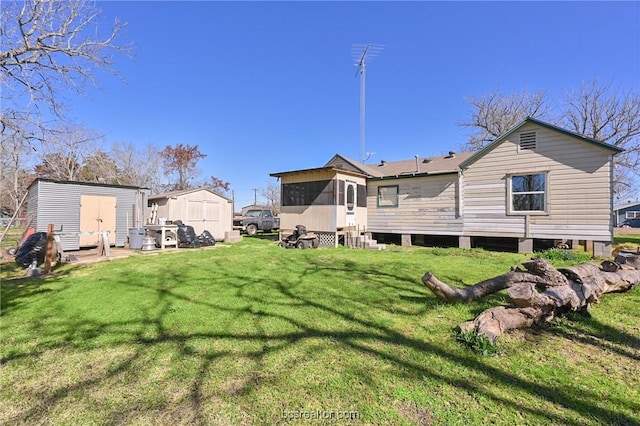 rear view of property with a yard and a shed