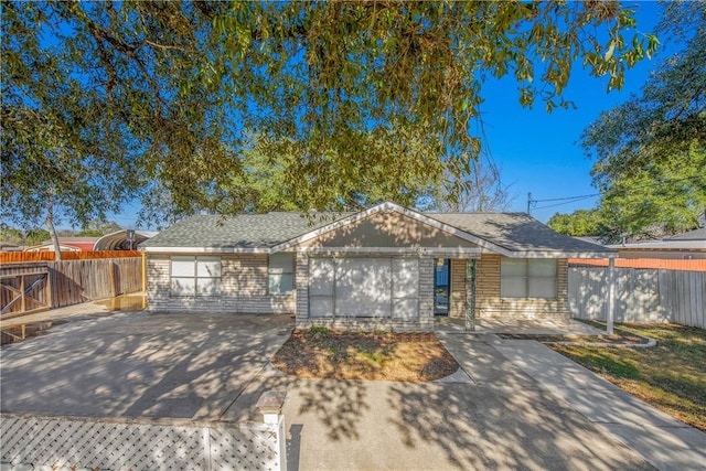 ranch-style home with a shingled roof and fence