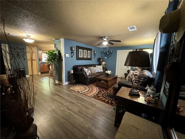 living room featuring hardwood / wood-style floors, ceiling fan, and a textured ceiling