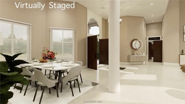 dining room featuring a towering ceiling