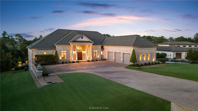 view of front of home with a garage and a lawn