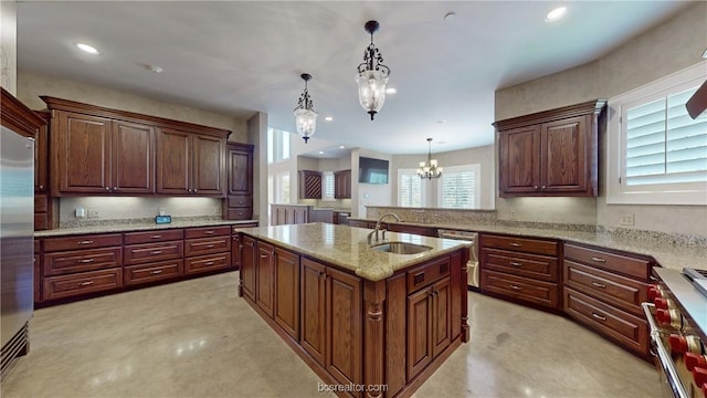 kitchen with high quality appliances, a kitchen island with sink, sink, and pendant lighting