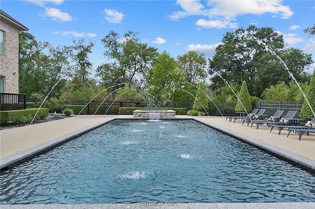 view of swimming pool with pool water feature and a patio area