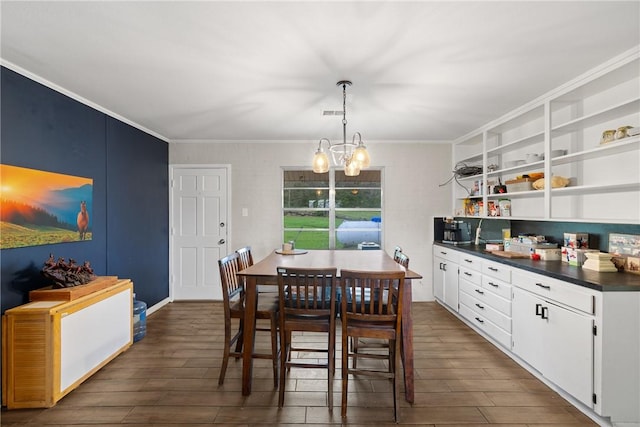 dining room featuring dark hardwood / wood-style floors, crown molding, and a notable chandelier