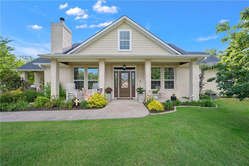 10187 Hampton Ct, Iola, TX 77861 - view of front of property with a front yard, a chimney, and covered porch