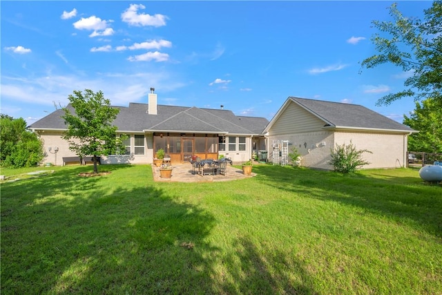 10187 Hampton Ct, Iola, TX 77861 - back of property featuring a sunroom, a yard, a patio area, and a chimney