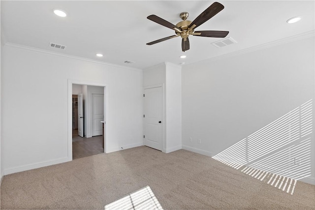 carpeted spare room with ceiling fan and crown molding