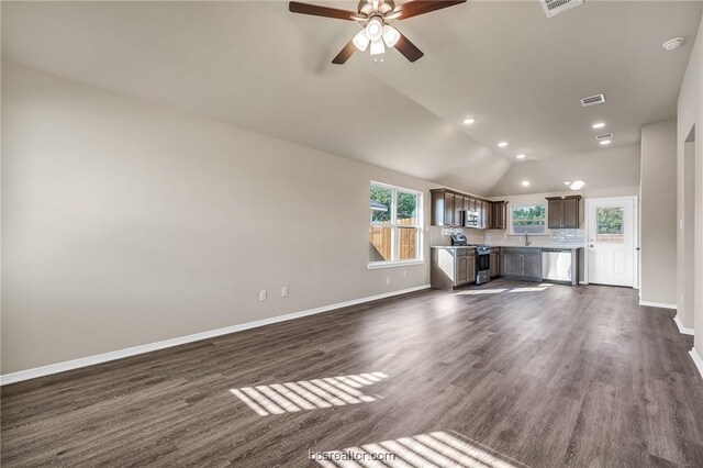 unfurnished living room featuring dark wood-type flooring, ceiling fan, sink, and vaulted ceiling