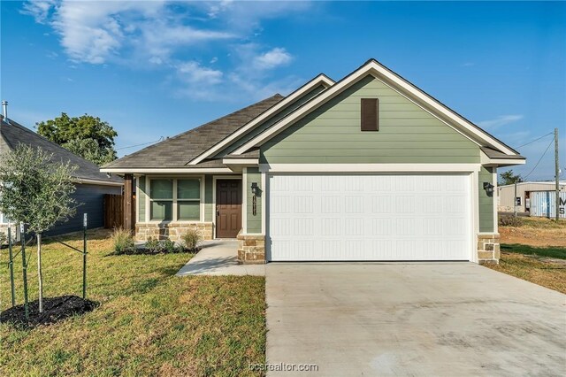 craftsman inspired home with a garage and a front yard