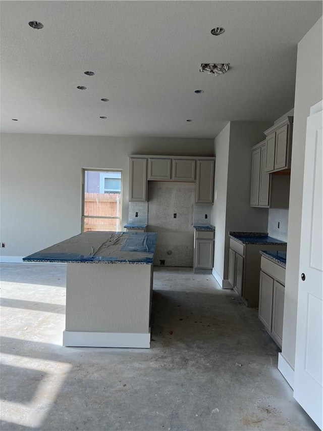 5307 Lyle Pl, Bryan, TX 77807 - kitchen with gray cabinets, a kitchen island, and concrete floors