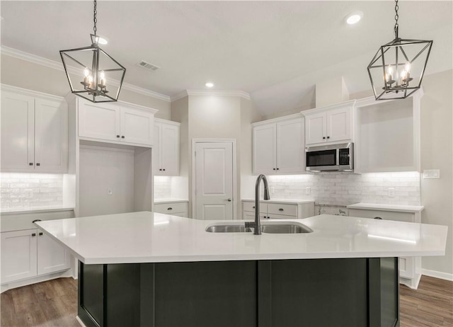 2816 Bombay Dr, Bryan, TX 77808 - kitchen featuring a center island with sink, decorative light fixtures, dark hardwood / wood-style floors, and sink