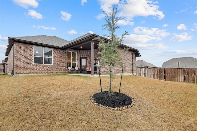 back of property with a yard and a patio area