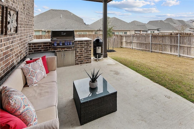 view of patio with a grill, an outdoor hangout area, and an outdoor kitchen