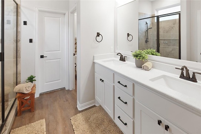 bathroom featuring hardwood / wood-style flooring, vanity, and walk in shower