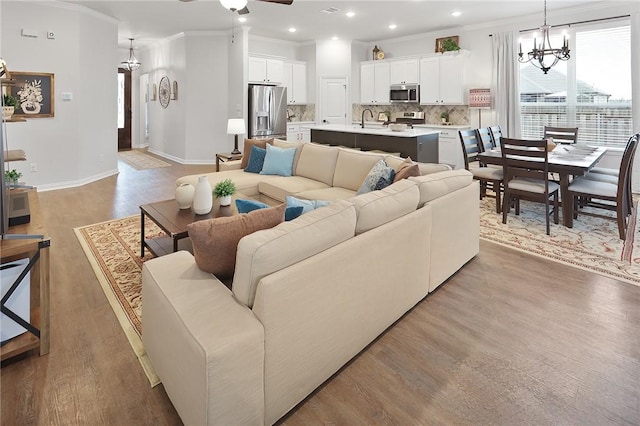 living room with crown molding, wood-type flooring, and sink